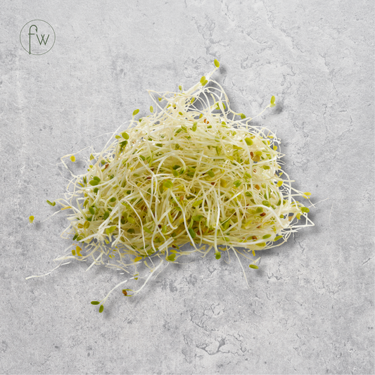 A small pile of fresh sprouts with pale white roots and light green tops, placed on a light gray textured surface. A small circular 'fw' logo appears in the upper left corner.