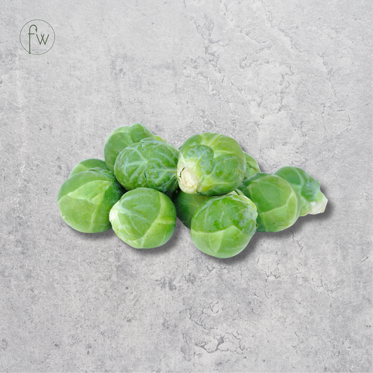 A small pile of fresh green Brussels sprouts centered on a light gray textured stone-like background. A small circular 'fw' logo appears in the upper left corner.