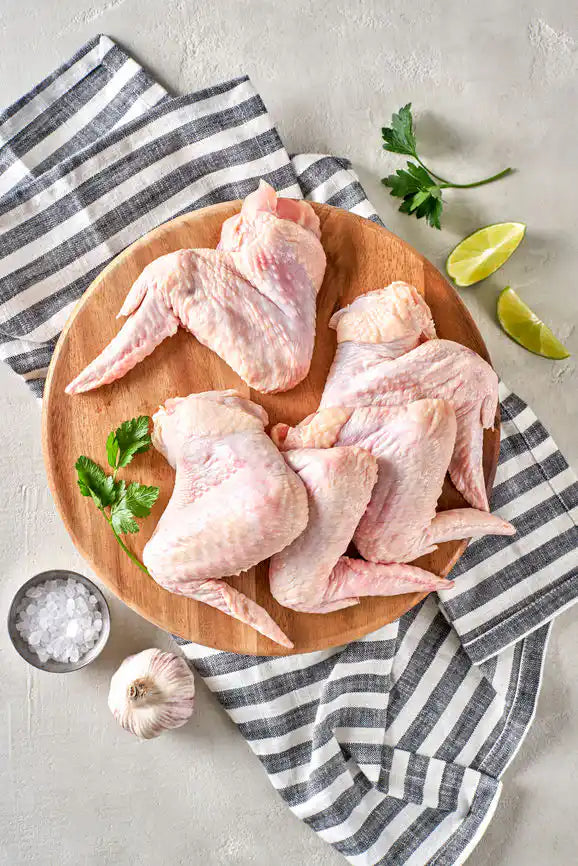 Marinated certified organic chicken wings on a plate.