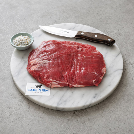 Cape Grime Lean Flank Steak on a Marble Plate with Sea salt and knife.