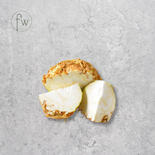 Sliced piece of turmeric root on a gray surface with 'fw' logo.
