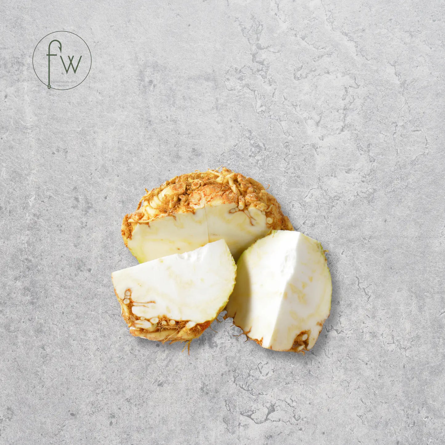 Sliced piece of turmeric root on a gray surface with 'fw' logo.