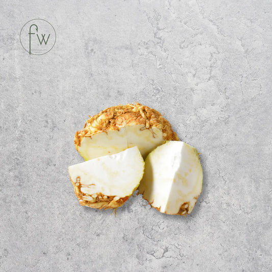 Sliced piece of turmeric root on a gray surface with 'fw' logo.