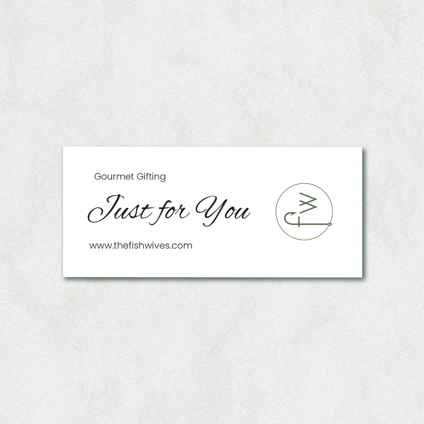 A white rectangular gift card with elegant black script reading 'Just for You' and 'Gourmet Gifting' above it, plus the website 'www.thefishwives.