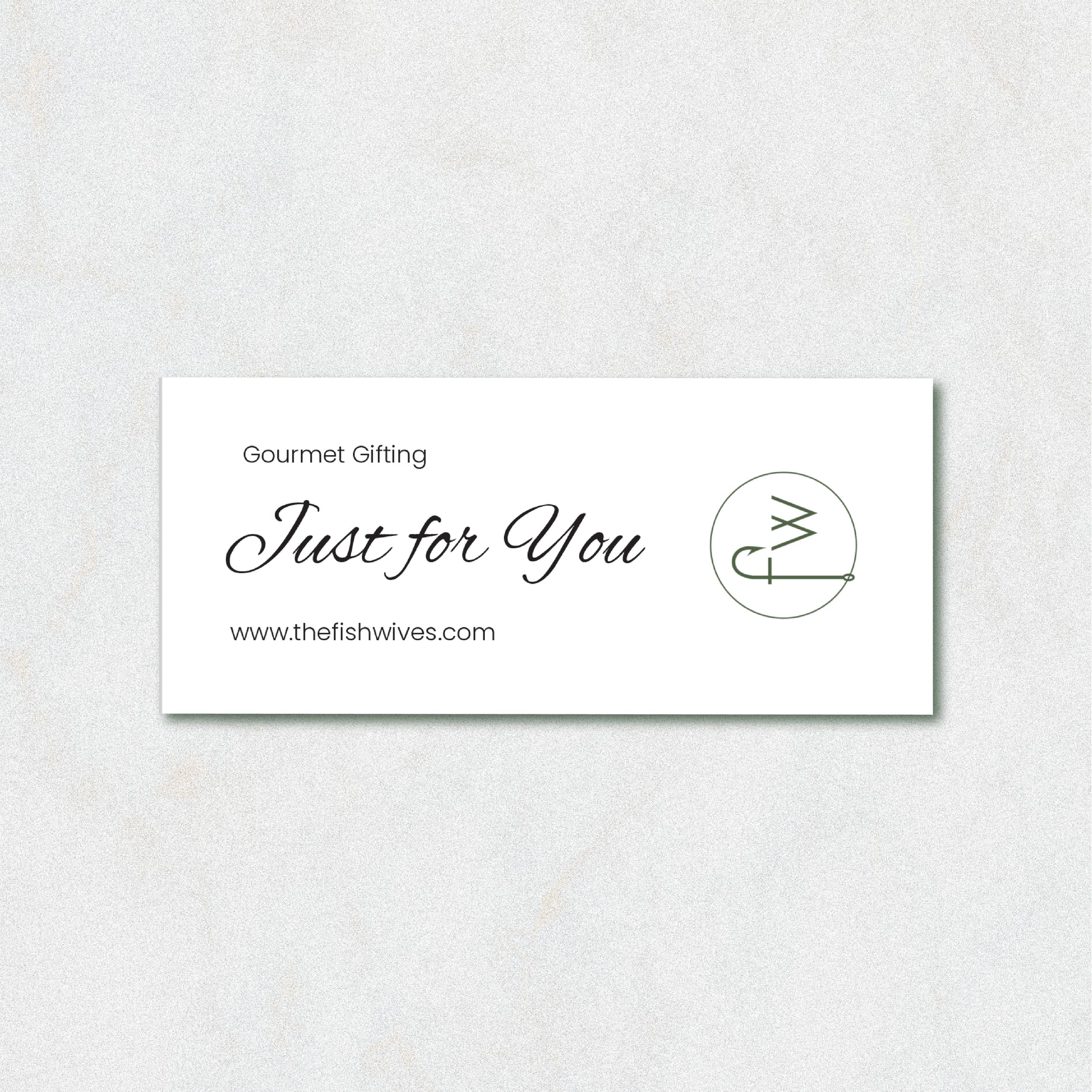 A white rectangular gift card with elegant black script reading 'Just for You' and 'Gourmet Gifting' above it, plus the website 'www.thefishwives.