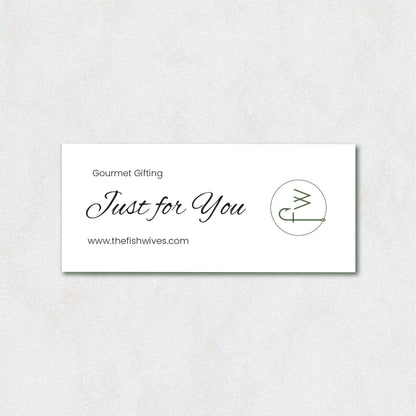 A white rectangular gift card with elegant black script reading 'Just for You' and 'Gourmet Gifting' above it, plus the website 'www.thefishwives.