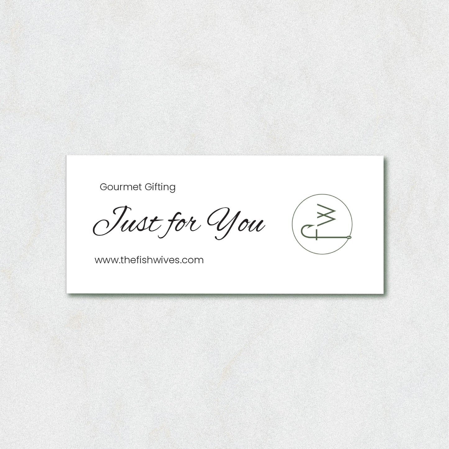 A white rectangular gift card with elegant black script reading 'Just for You' and 'Gourmet Gifting' above it, plus the website 'www.thefishwives.