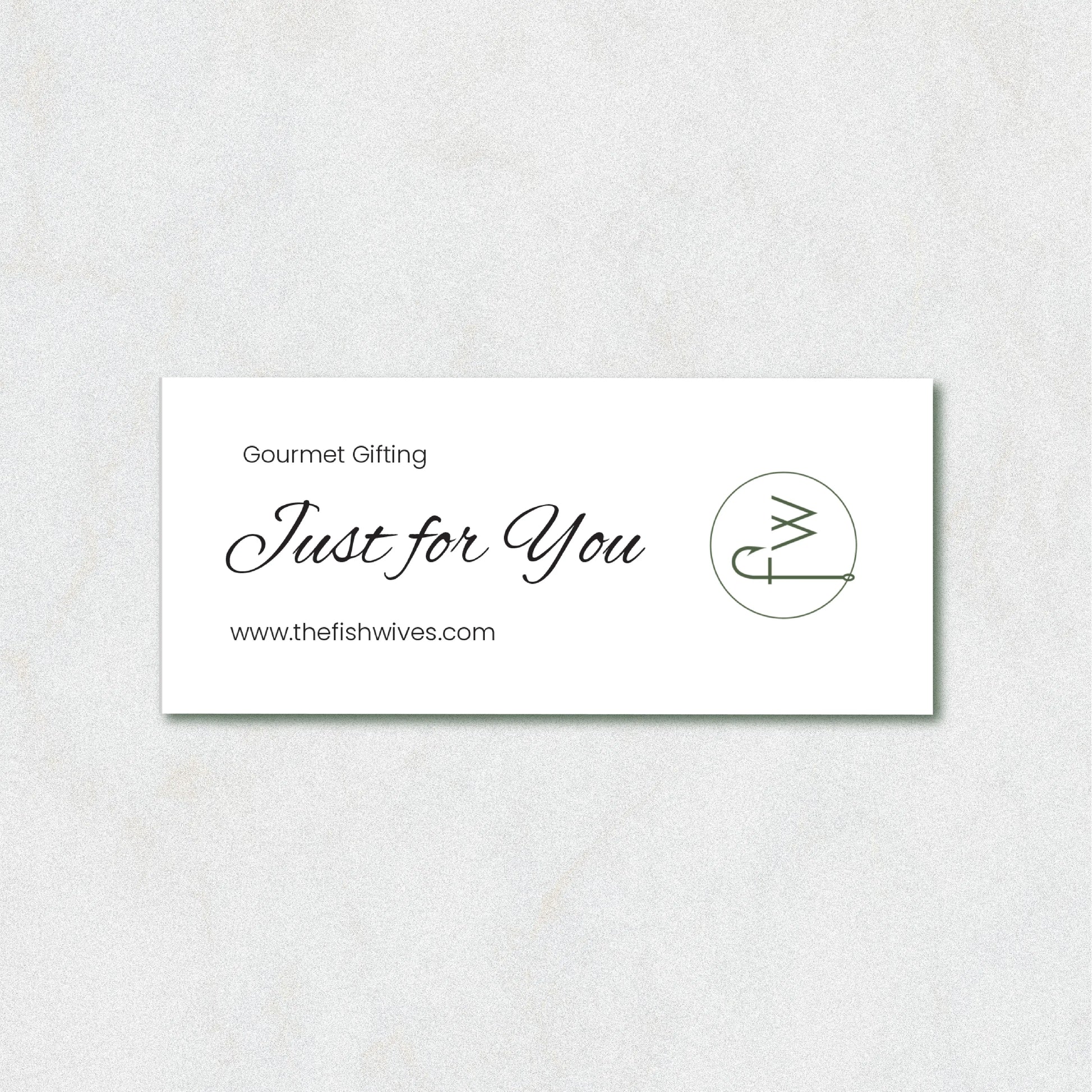 A white rectangular gift card with elegant black script reading 'Just for You' and 'Gourmet Gifting' above it, plus the website 'www.thefishwives.