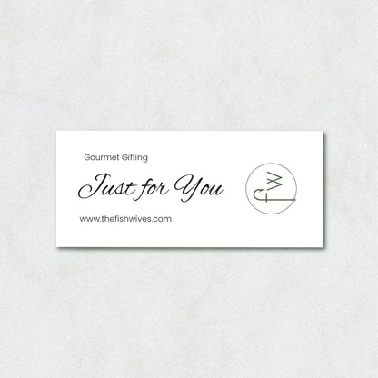 A white rectangular gift card with elegant black script reading 'Just for You' and 'Gourmet Gifting' above it, plus the website 'www.thefishwives.