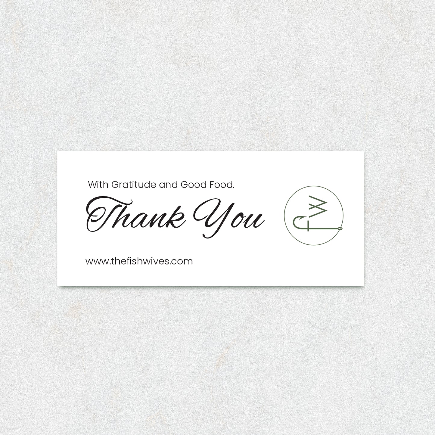 A rectangular white thank-you card with elegant black script reading 'Thank You' and smaller text 'With Gratitude and Good Food.' and 'www.