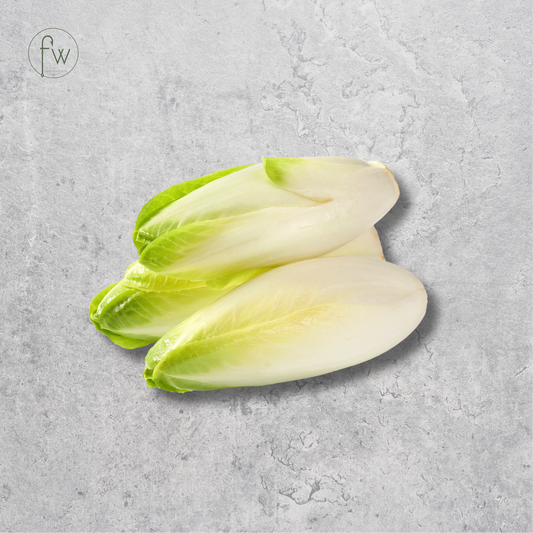 Two pale green and off-white lettuce leaves arranged on a textured light gray surface, with a small circular 'fw' logo in the upper left corner.