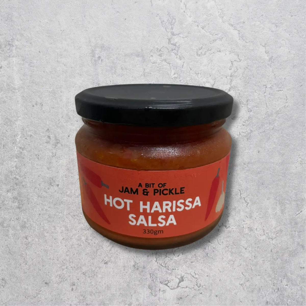 Jam & Pickle hot harissa salsa jar on a light background.