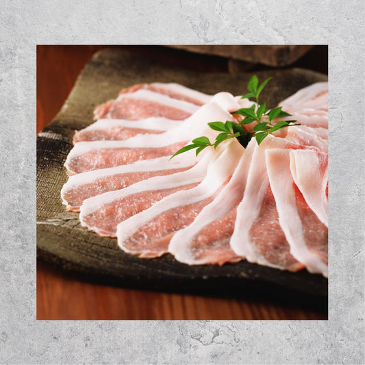 Raw iberico pork meat slices on a plate with a garnish on a wooden surface