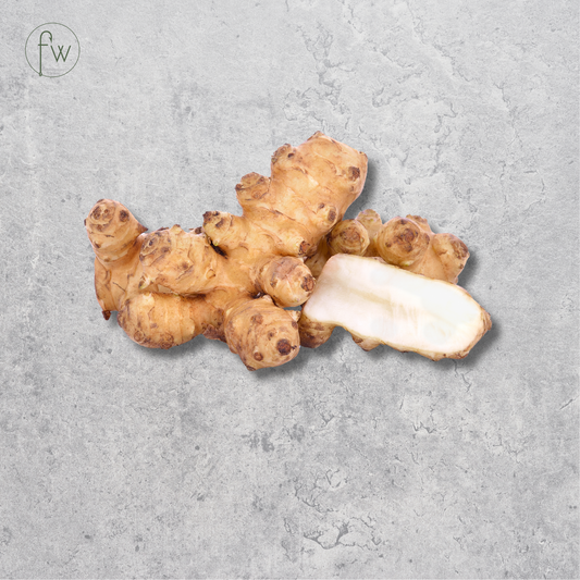 A cluster of fresh jicama roots with one cut piece showing the white interior, set against a textured gray background with a small 'fw' logo in the top-left corner.
