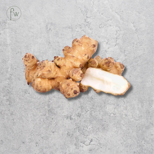 A cluster of fresh jicama roots with one cut piece showing the white interior, set against a textured gray background with a small 'fw' logo in the top-left corner.