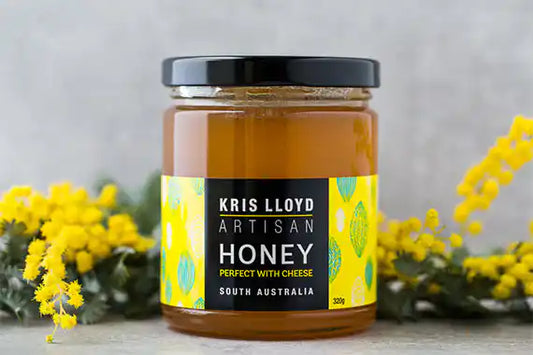 Kris Lloyd pure honey jar on a light background.