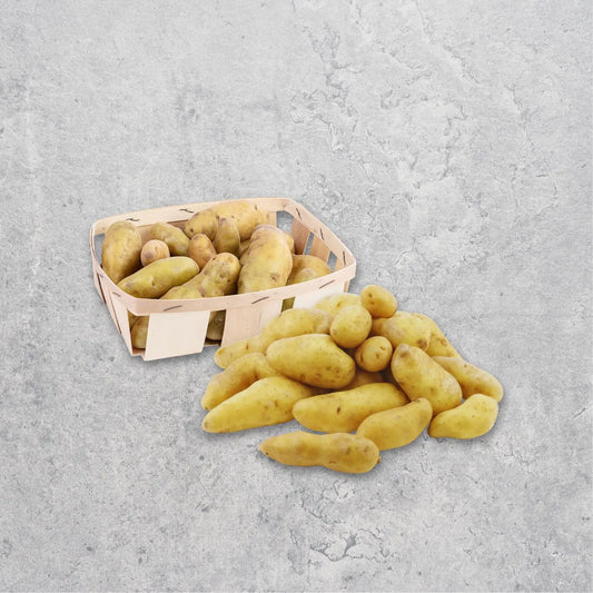 Basket and pile of potatoes on a gray concrete surface