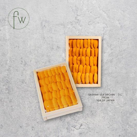 Two wooden trays filled with yellow sea urchin on a gray concrete background, featuring the brand 'fw'.