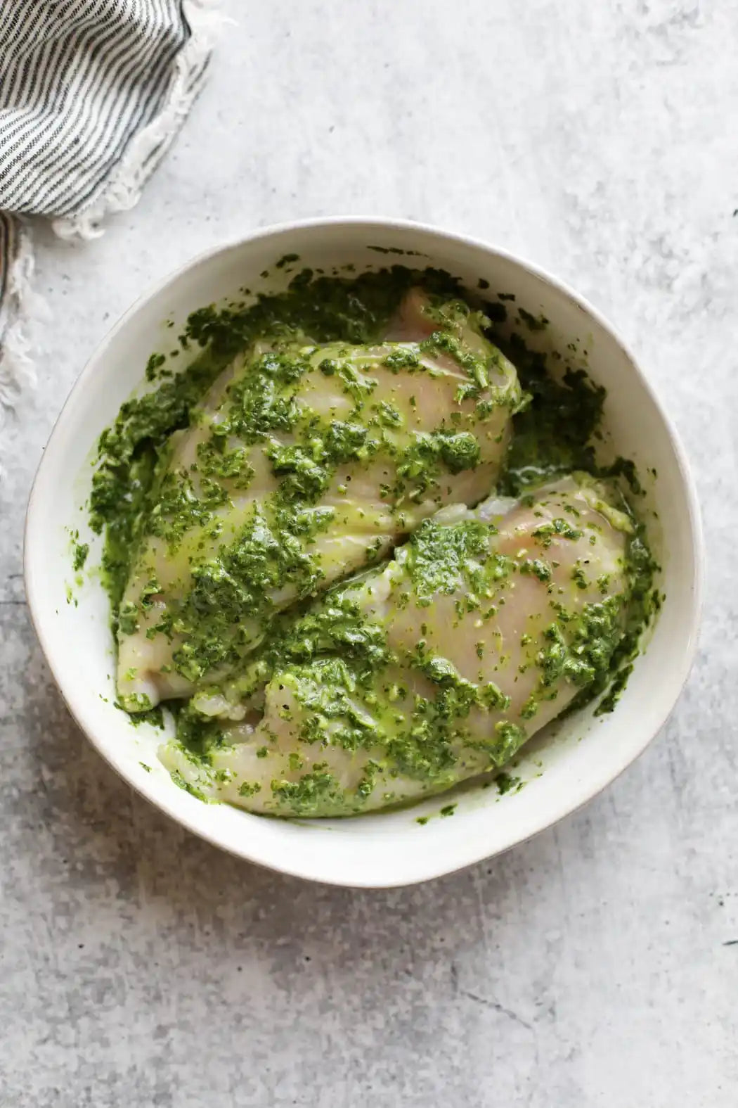 Basil pesto marinated chicken breast in packaging.