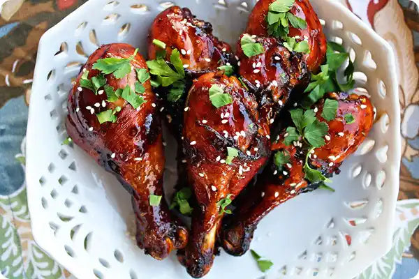 Marinated certified organic chicken drumsticks close-up.